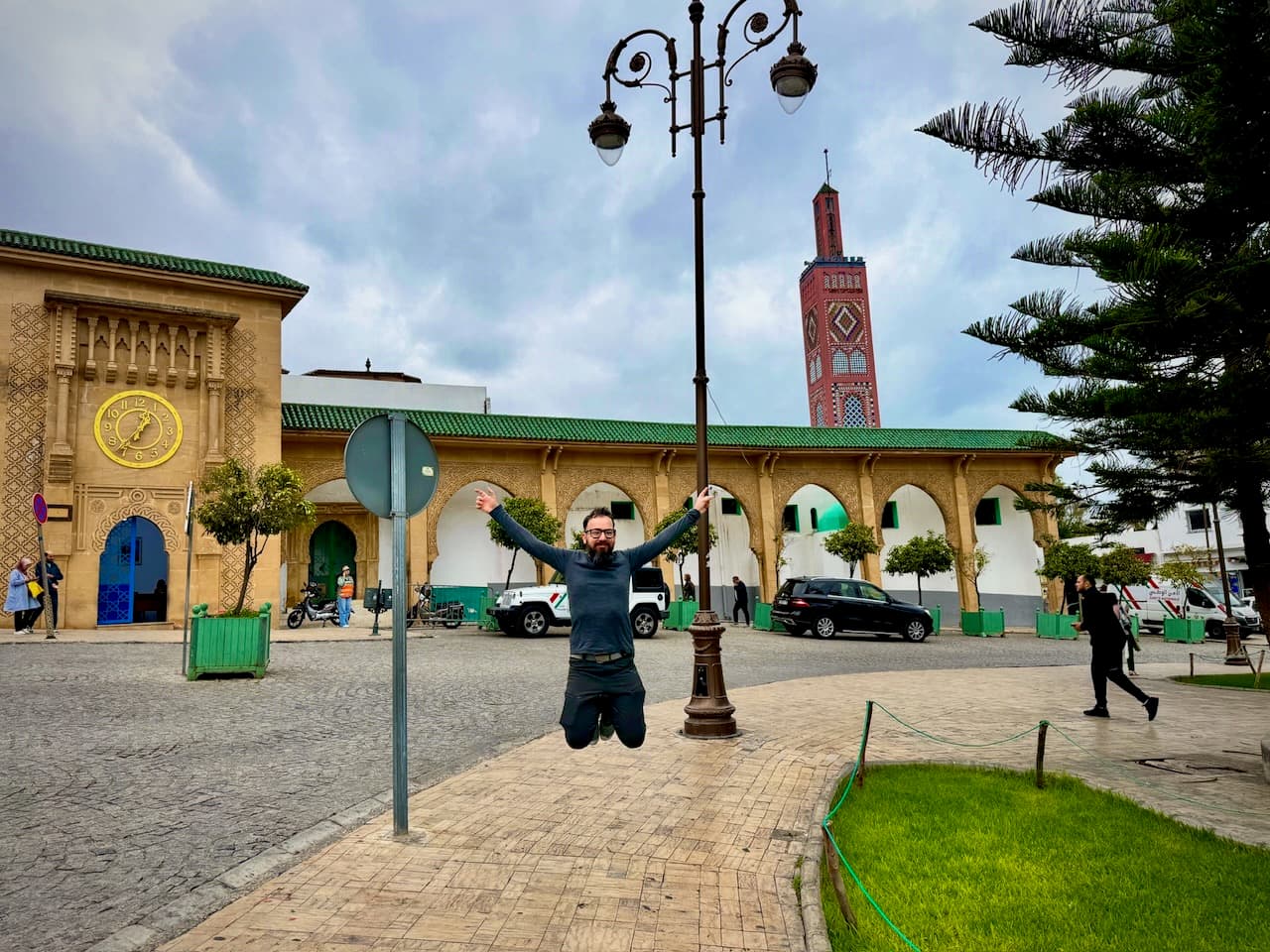 Jumping on the Grand Socco, with the tiled minaret of the Sidi Bou Abid mosque behind