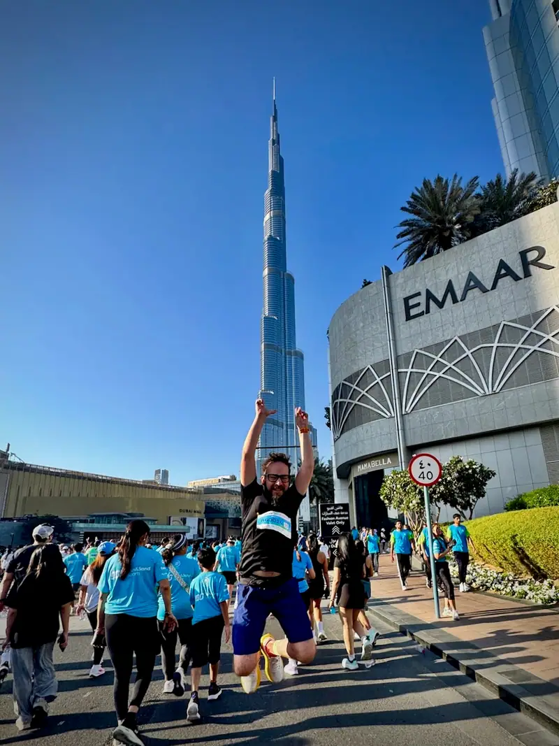Jumping in the middle of a crowd of runners in Downtown Dubai, with the Burj Khalifa towering behind
